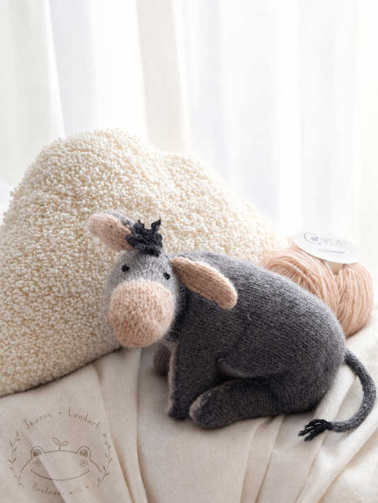 Tricot représentant l'âne de Winnie l'ourson et un coussin en forme de nuage
